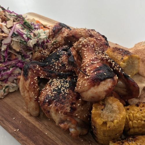 Πιάτο με ψημένα παϊδάκια κοτόπουλο BBQ, Coleslaw με κόκκινο και λευκό λάχανο, και καλαμπόκι βουτυρωμένο με κύμινο