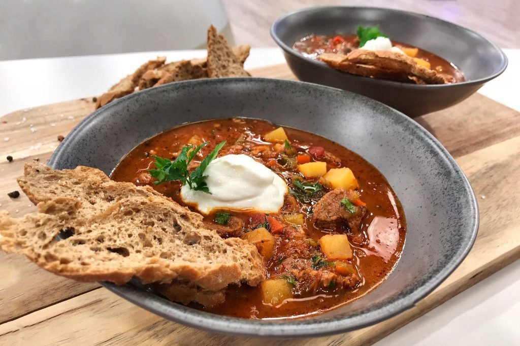 Βαθύ πιάτο με ουγγρικό goulash σούπα γεμάτη με κομμάτια μοσχάρι, πατάτες κύβους και κόκκινο ζωμό με πάπρικα