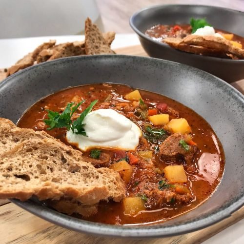 Βαθύ πιάτο με ουγγρικό goulash σούπα γεμάτη με κομμάτια μοσχάρι, πατάτες κύβους και κόκκινο ζωμό με πάπρικα