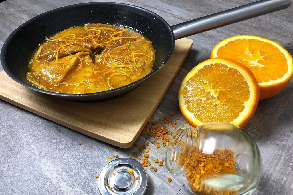 Crêpes Suzette, λεπτές κρέπες φλαμπέ σε σάλτσα πορτοκαλιού, ένα κλασικό γαλλικό επιδόρπιο στο πιάτο