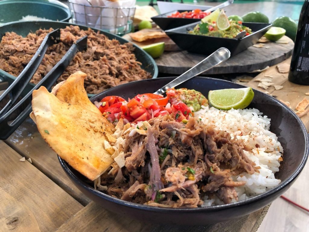 Pulled pork που ξεφτίζει από τρυφερότητα, σερβιρισμένο με ρύζι και δροσερό guacamole