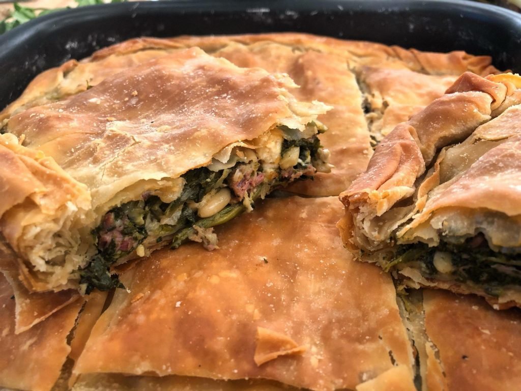 Αρωματική πίτα με αρνάκι και πράσινα λαχανικά, με τη ζύμη να αγκαλιάζει το μυρωδάτο κρέας