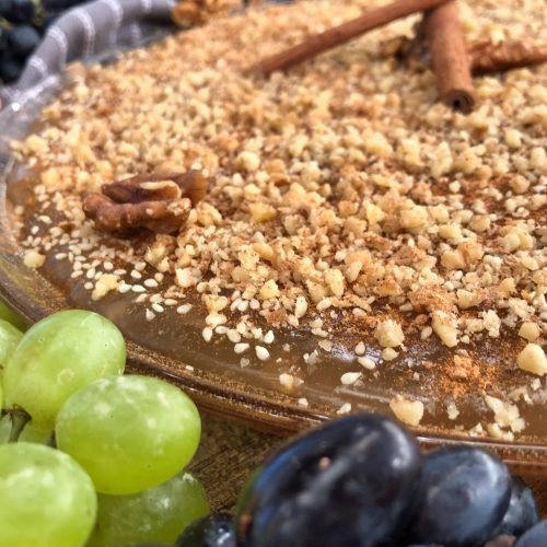 Παραδοσιακή μουσταλευριά από μούστο σταφυλιού με πηχτή βελούδινη υφή, πασπαλισμένη με κανέλα και καρύδι