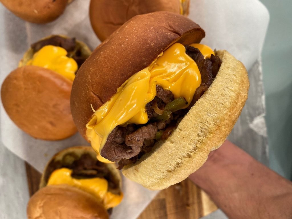 Philly cheesesteak burger με ζουμερό κρέας, λιωμένο τυρί και καραμελωμένα κρεμμύδια